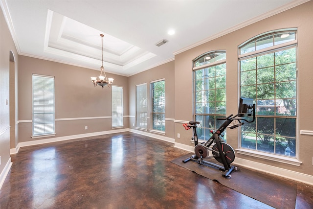 exercise area with a notable chandelier, ornamental molding, and a raised ceiling