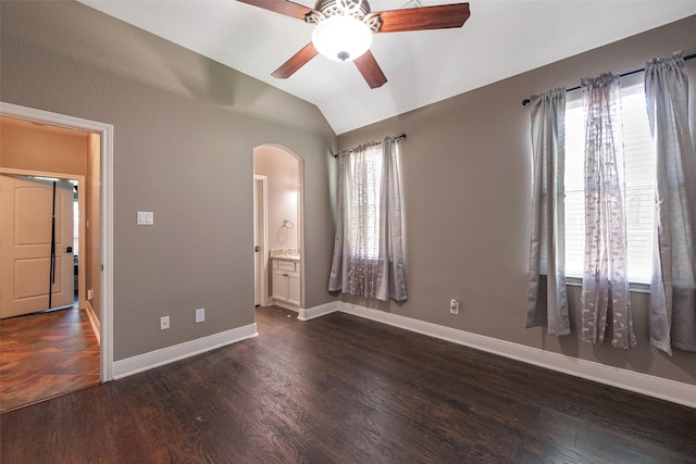 unfurnished bedroom featuring ensuite bath, lofted ceiling, dark hardwood / wood-style floors, and multiple windows