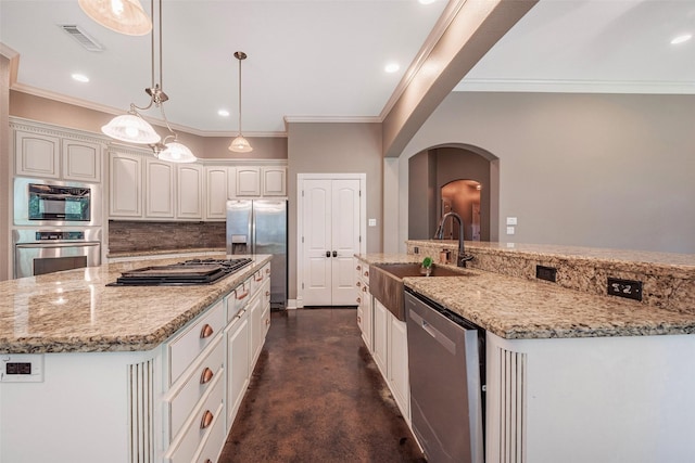 kitchen featuring sink, appliances with stainless steel finishes, a spacious island, white cabinets, and decorative light fixtures