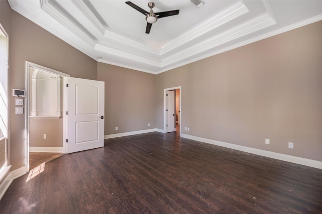 unfurnished room with a tray ceiling, dark wood-type flooring, ornamental molding, and ceiling fan