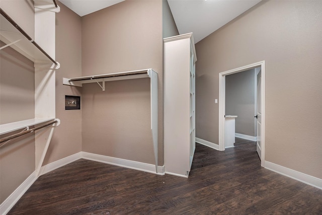 walk in closet with dark wood-type flooring and vaulted ceiling