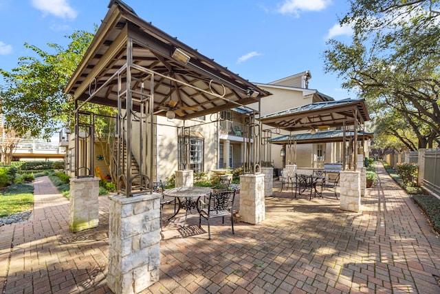 view of patio / terrace with outdoor dining space, fence, exterior kitchen, and a gazebo