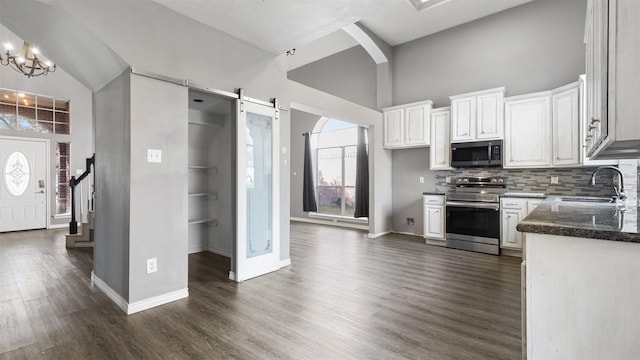 kitchen featuring a barn door, white cabinetry, appliances with stainless steel finishes, and sink