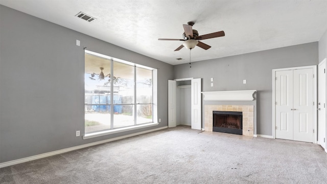 unfurnished living room featuring ceiling fan, a fireplace, and carpet floors