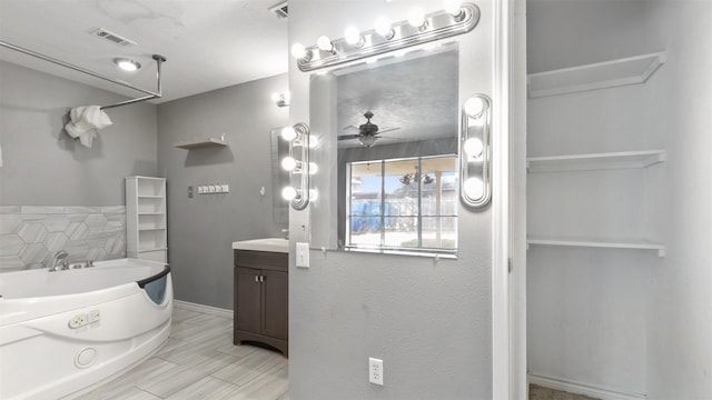 bathroom featuring a washtub, vanity, and ceiling fan