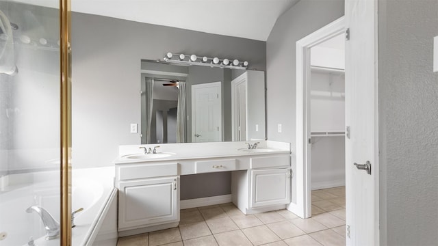 bathroom with tile patterned flooring, vanity, and a bath