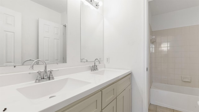 bathroom featuring tile patterned flooring, vanity, and tiled shower / bath combo