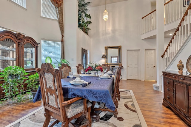 dining space featuring light hardwood / wood-style floors and a high ceiling