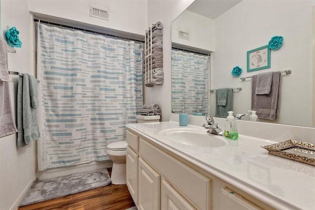 bathroom with wood-type flooring, toilet, and vanity