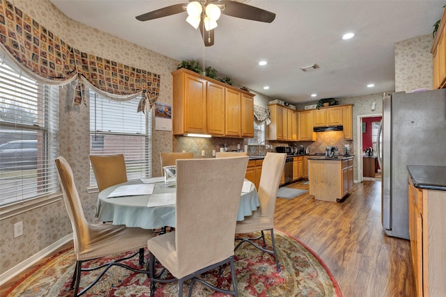 dining space with ceiling fan and light wood-type flooring