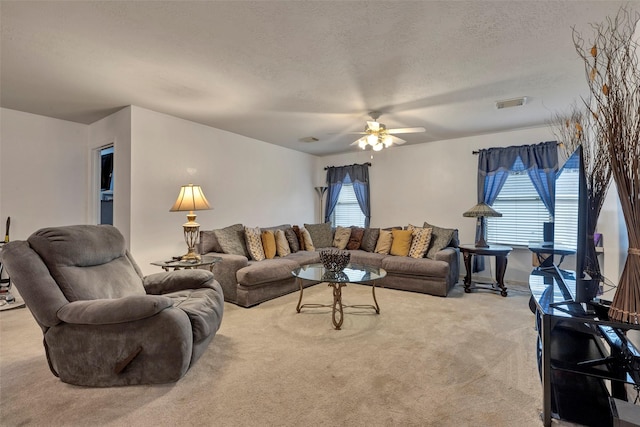 carpeted living room featuring ceiling fan and a textured ceiling