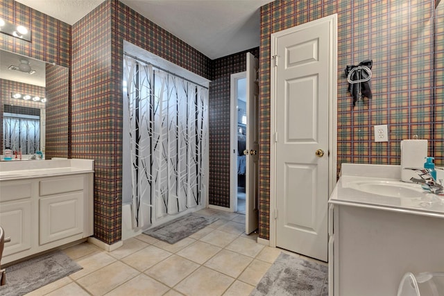 bathroom with tile patterned flooring, vanity, shower / bath combo, and a textured ceiling