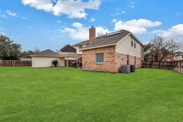 rear view of property featuring a yard and central AC unit