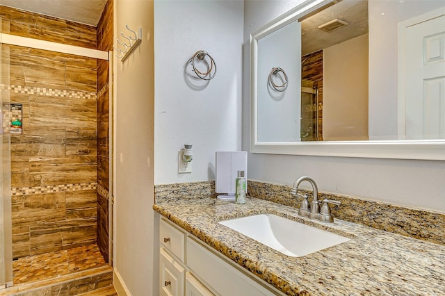 bathroom with vanity and tiled shower