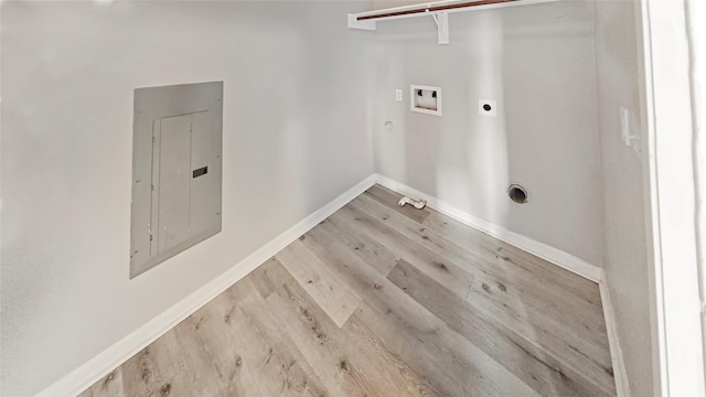 clothes washing area featuring light hardwood / wood-style flooring, electric dryer hookup, electric panel, washer hookup, and hookup for a gas dryer