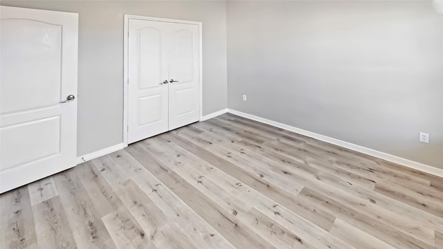 unfurnished bedroom featuring a closet and light hardwood / wood-style flooring