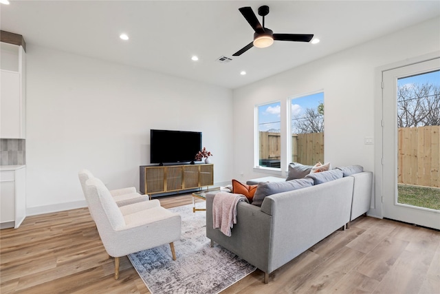 living room with light hardwood / wood-style flooring and ceiling fan