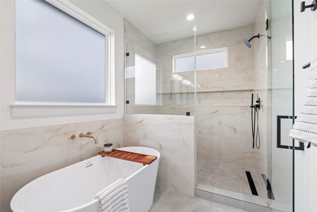 bathroom with separate shower and tub and tile walls