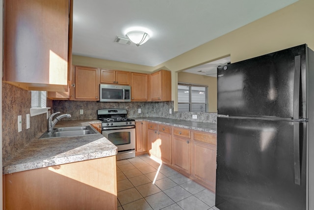 kitchen featuring light tile patterned flooring, stainless steel appliances, sink, and tasteful backsplash