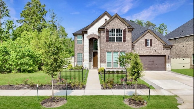 french country style house featuring a garage and a front lawn