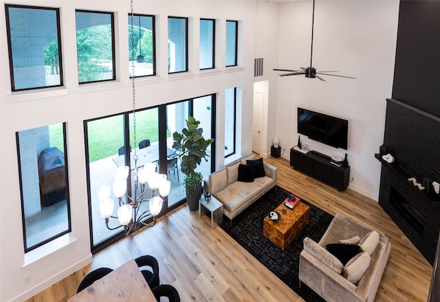 living room with plenty of natural light, light hardwood / wood-style floors, and a high ceiling