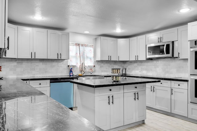 kitchen featuring stainless steel appliances, sink, light hardwood / wood-style flooring, and white cabinets