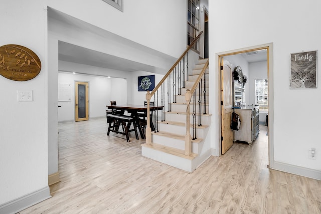 stairway featuring hardwood / wood-style flooring and a high ceiling