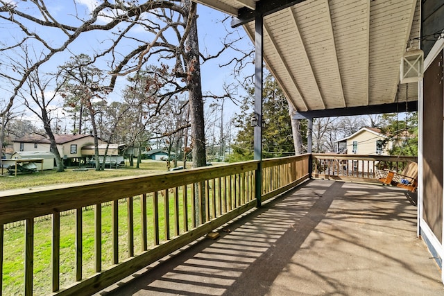 wooden deck featuring a lawn