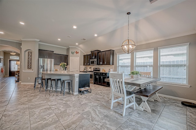 dining space with an inviting chandelier, ornamental molding, and lofted ceiling