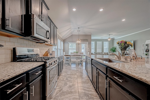 kitchen with sink, hanging light fixtures, stainless steel appliances, light stone countertops, and decorative backsplash