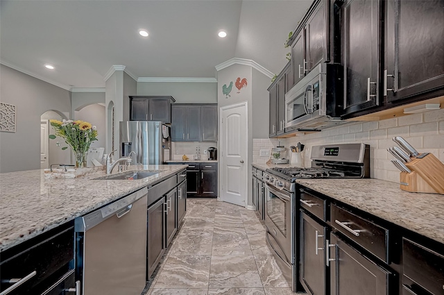 kitchen with sink, light stone counters, crown molding, tasteful backsplash, and appliances with stainless steel finishes