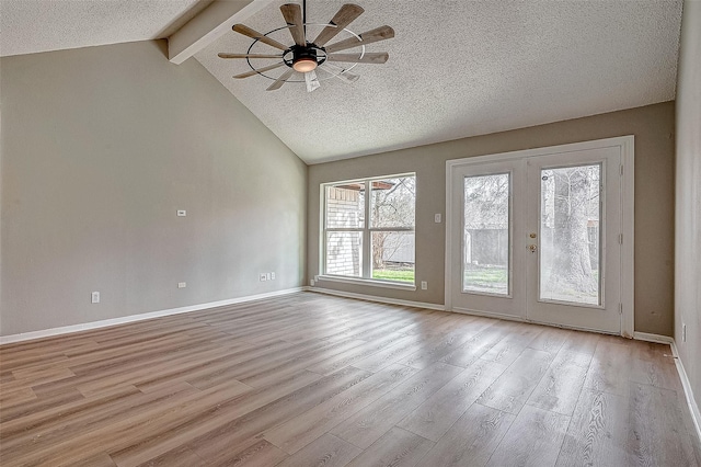 empty room featuring beam ceiling, light hardwood / wood-style floors, french doors, and a textured ceiling