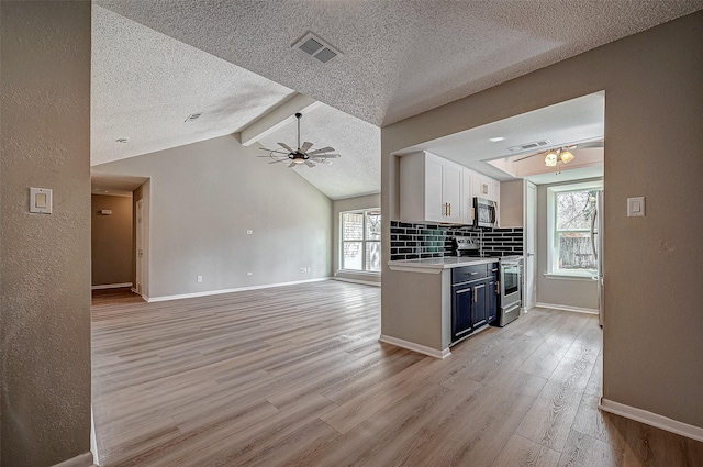 kitchen with blue cabinets, white cabinetry, appliances with stainless steel finishes, and light hardwood / wood-style flooring