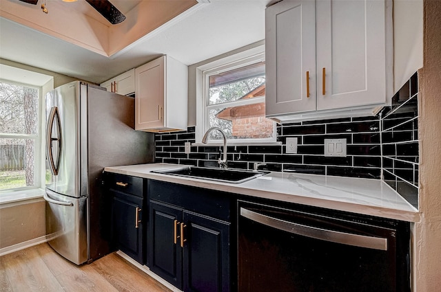 kitchen featuring white cabinetry, dishwasher, sink, and backsplash