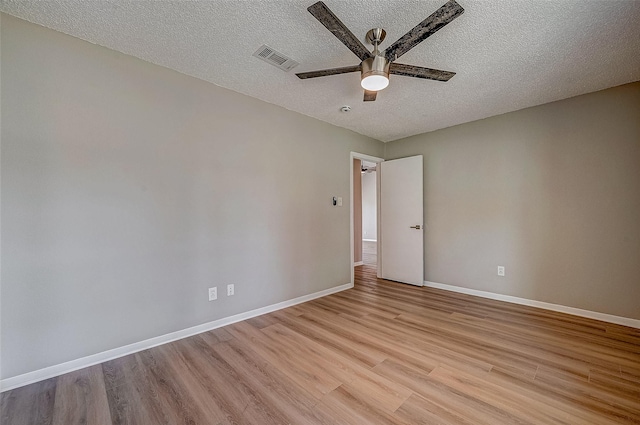 empty room with ceiling fan, a textured ceiling, and light wood-type flooring