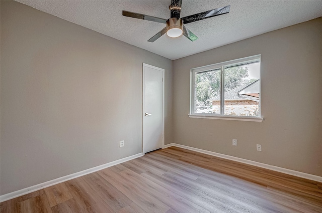 spare room with ceiling fan, a textured ceiling, and light wood-type flooring