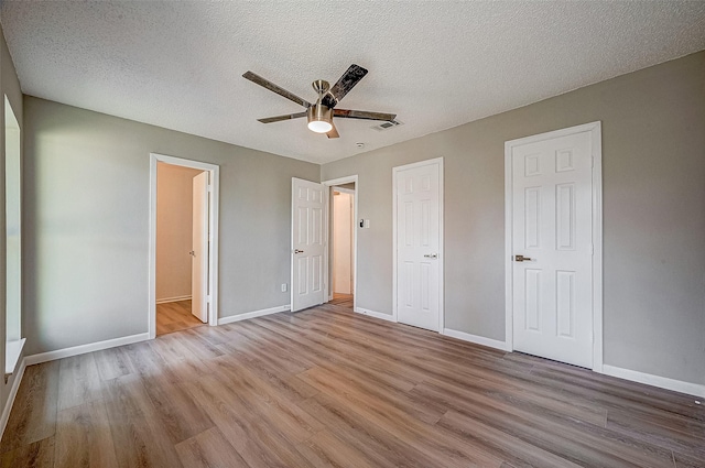 unfurnished bedroom with ceiling fan, a textured ceiling, and light wood-type flooring