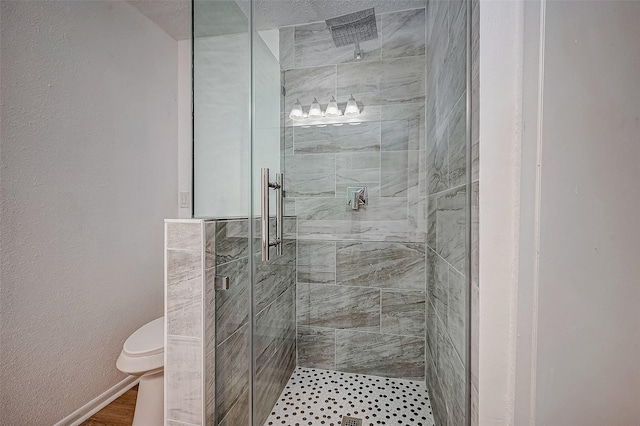 bathroom with toilet and a shower with shower door