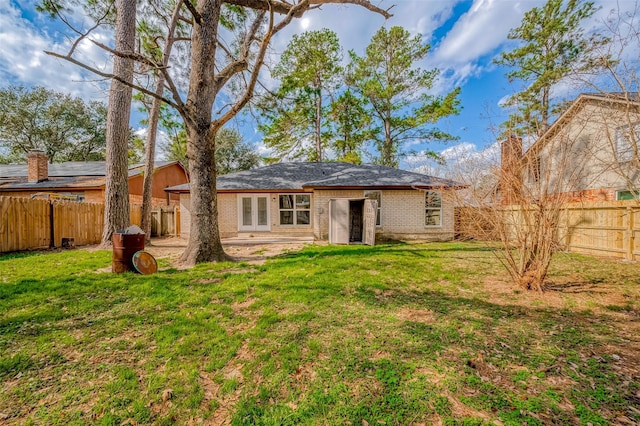 rear view of house featuring a yard