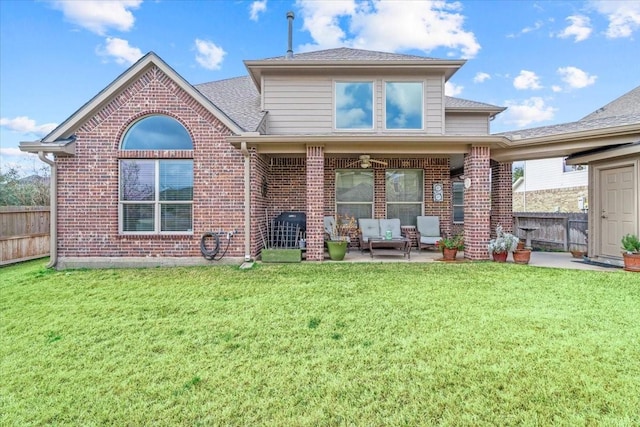 rear view of property with a yard and a patio