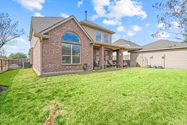 rear view of house featuring a yard and central AC unit