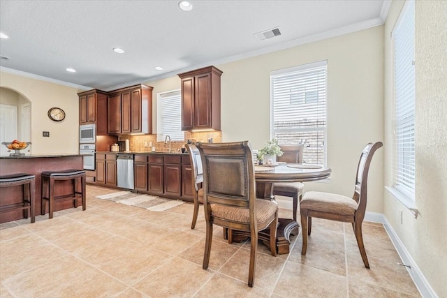 kitchen featuring tasteful backsplash, sink, crown molding, and stainless steel appliances