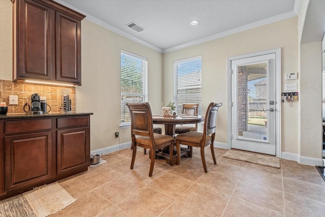 dining room with ornamental molding and light tile patterned floors