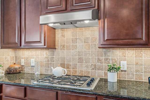 kitchen with stainless steel gas stovetop, dark stone counters, decorative backsplash, and exhaust hood