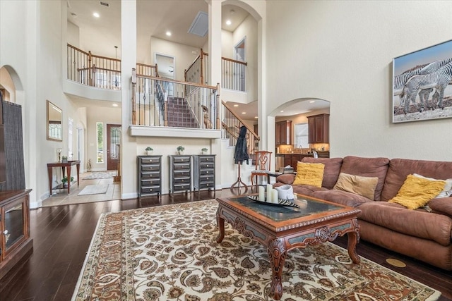 living room with a high ceiling and dark hardwood / wood-style floors