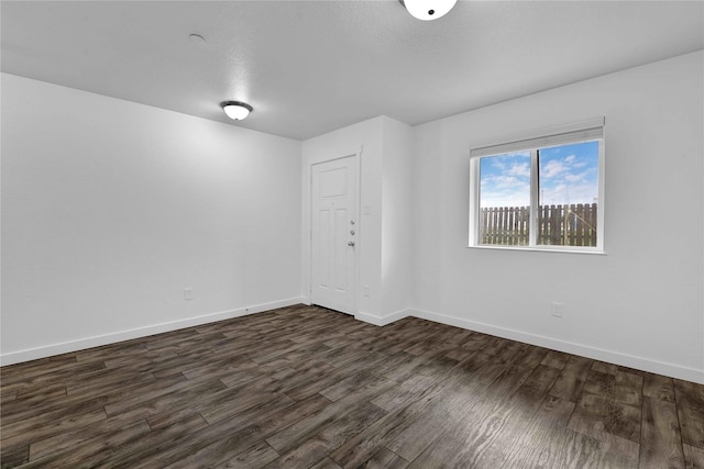 empty room with dark hardwood / wood-style flooring