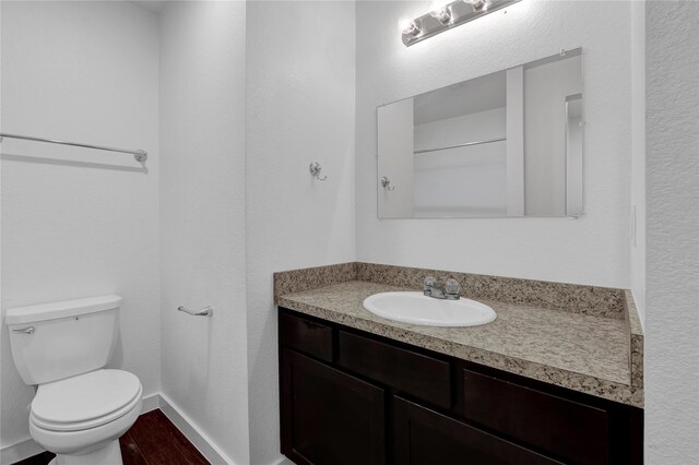 bathroom featuring vanity, hardwood / wood-style floors, and toilet