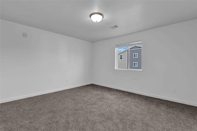 empty room featuring a textured ceiling and carpet flooring