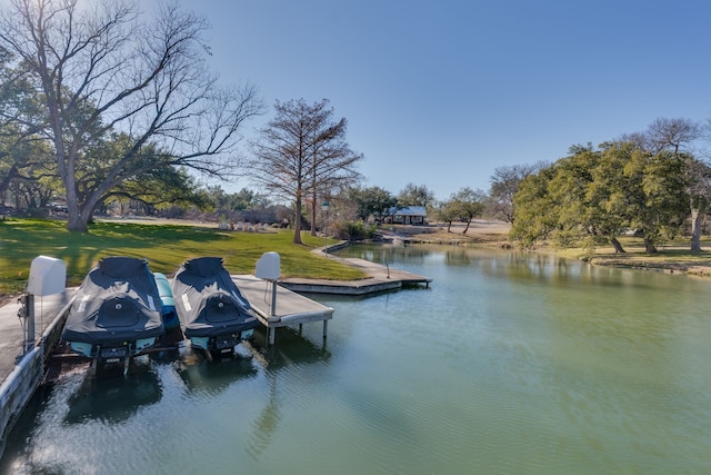 dock area with a water view and a yard