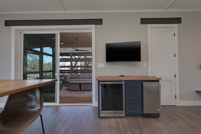 bar featuring beverage cooler, butcher block counters, and hardwood / wood-style floors